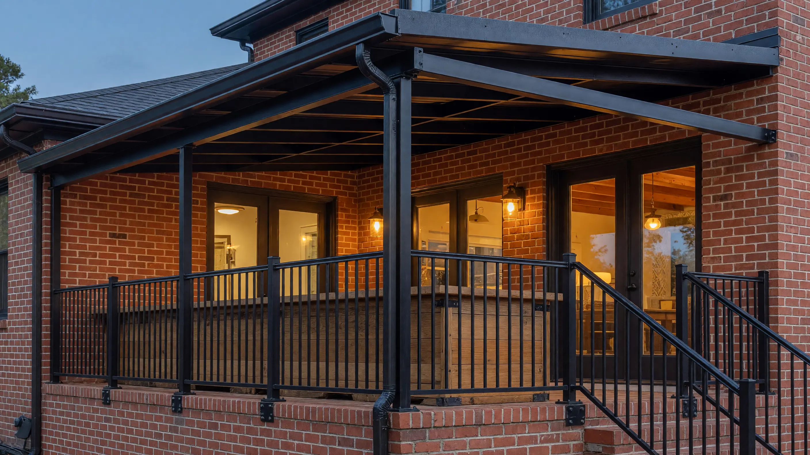 Coordinated black railing and fixed metal awning on the same renovated patio