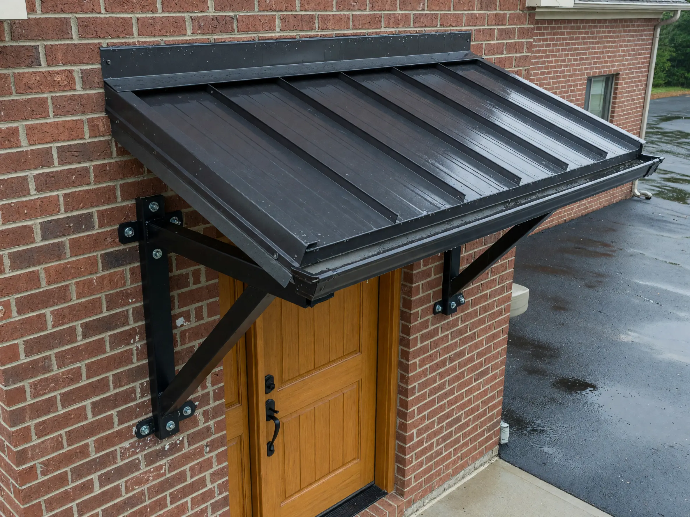Compact fixed metal canopy above a modern residential entry door