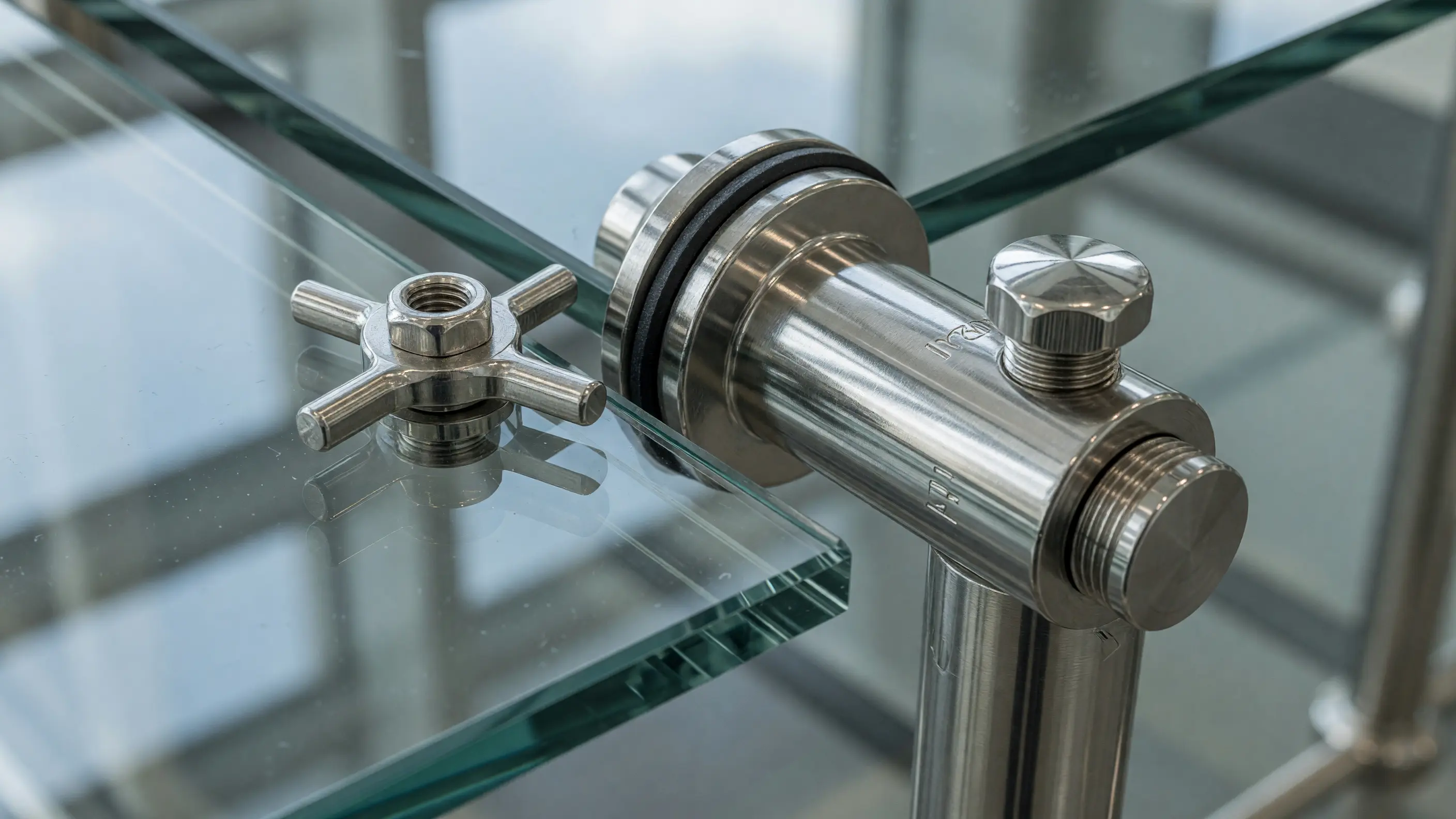 Close detail of polished stainless standoff hardware supporting a low-iron glass guard panel